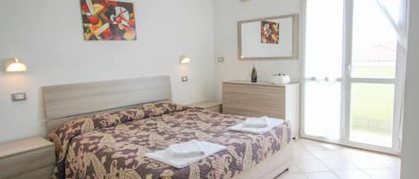 A bedroom with a large bed, a nightstand, a dresser, and a mirror.