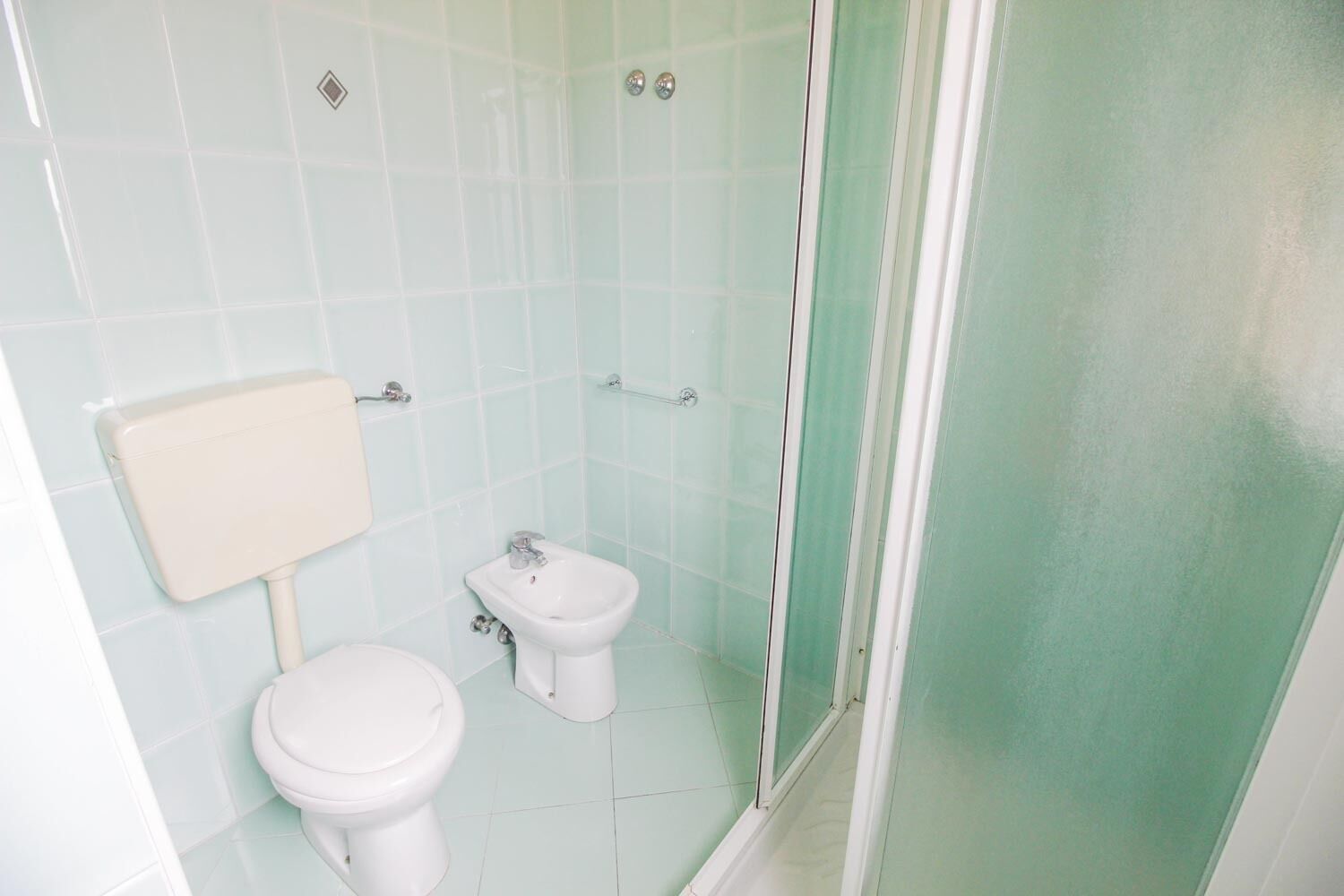 Une petite salle de bain comprenant des toilettes, un bidet et une douche.