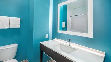 Un baño con lavamanos blanco, un espejo y un inodoro.