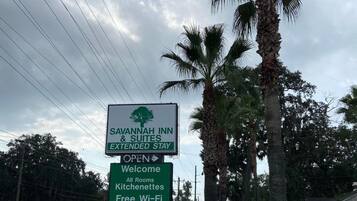 Skilt for Savannah Inn & Suites, der reklamerer for langtidsophold, ledige værelser, tekøkken og gratis Wi-Fi.