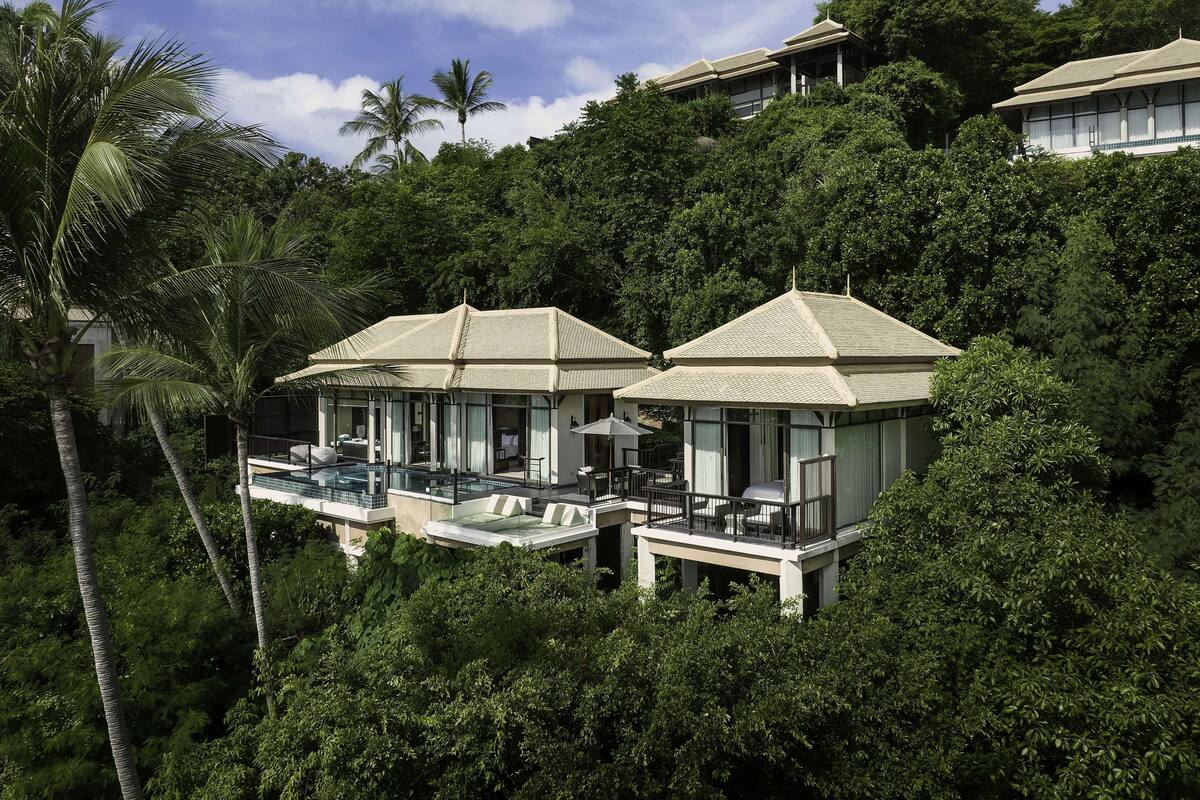 A resort with multiple overwater bungalows, each featuring a private pool and a balcony with outdoor furniture.