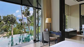 Une chambre d’hôtel dotée d’une grande fenêtre, d’un bureau, d’une chaise, d’un lit et d’une salle de bain avec un lavabo et un miroir.
