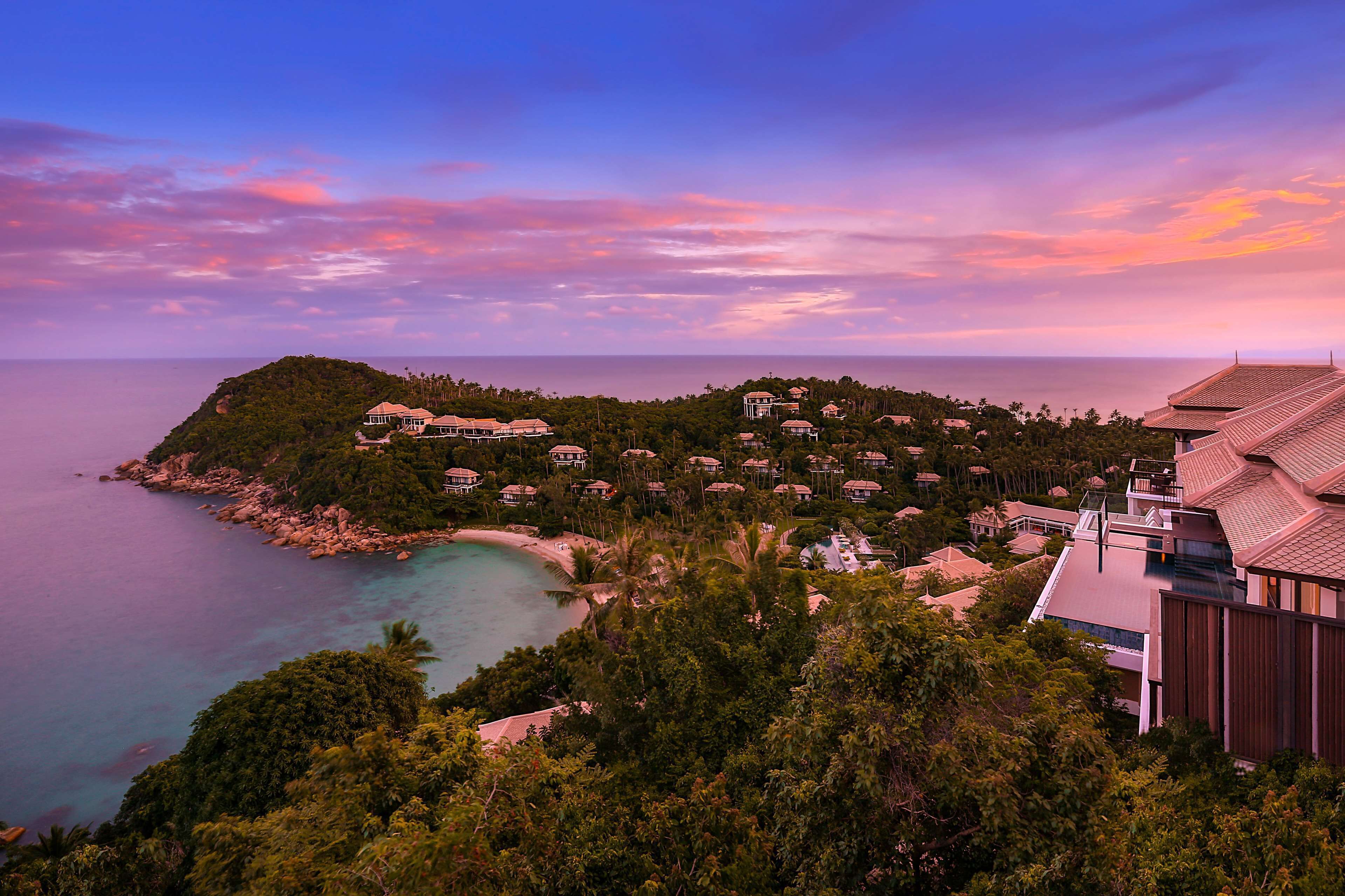 A coastal resort with multiple villas, a beach, and a view of the sea.