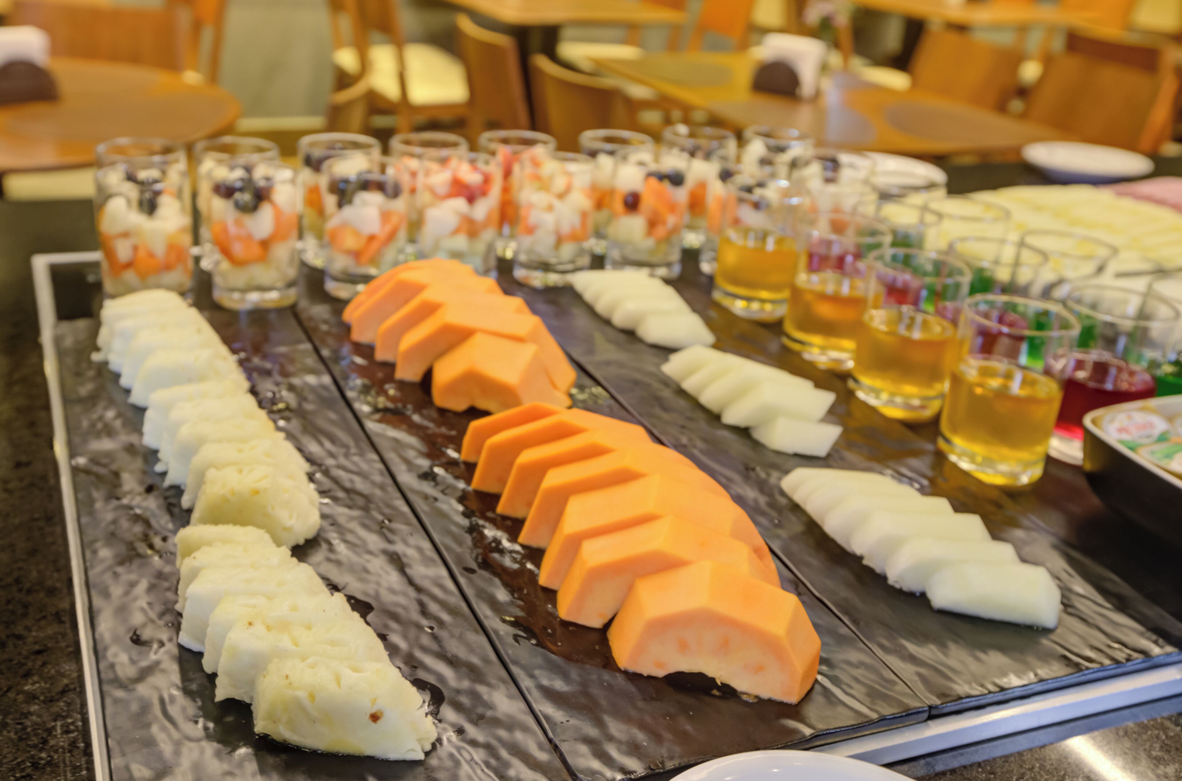 Un buffet proposant une variété de plats, notamment des viandes et des fruits coupés en tranches.