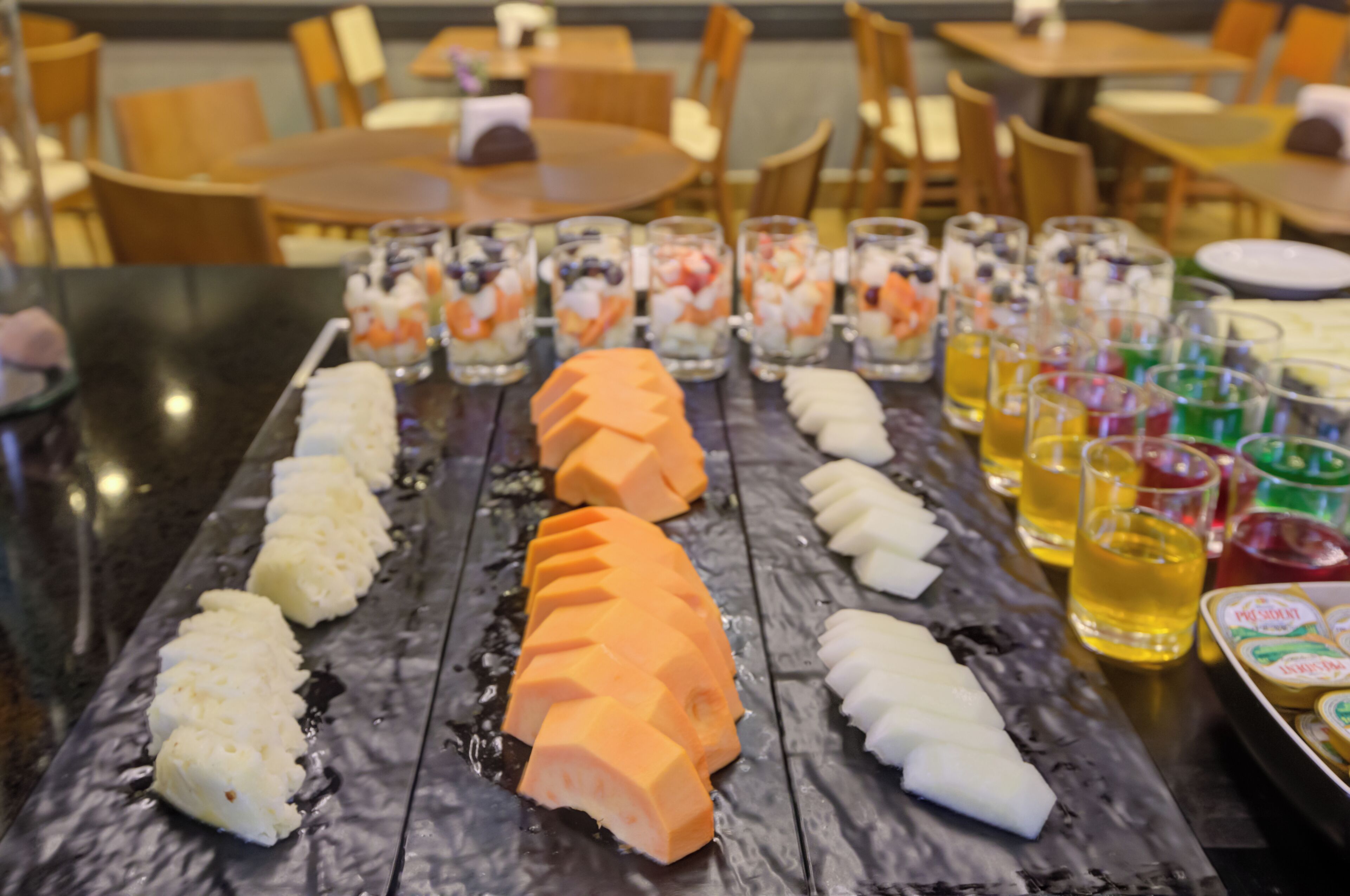 A dining table with various food items and drinks.
