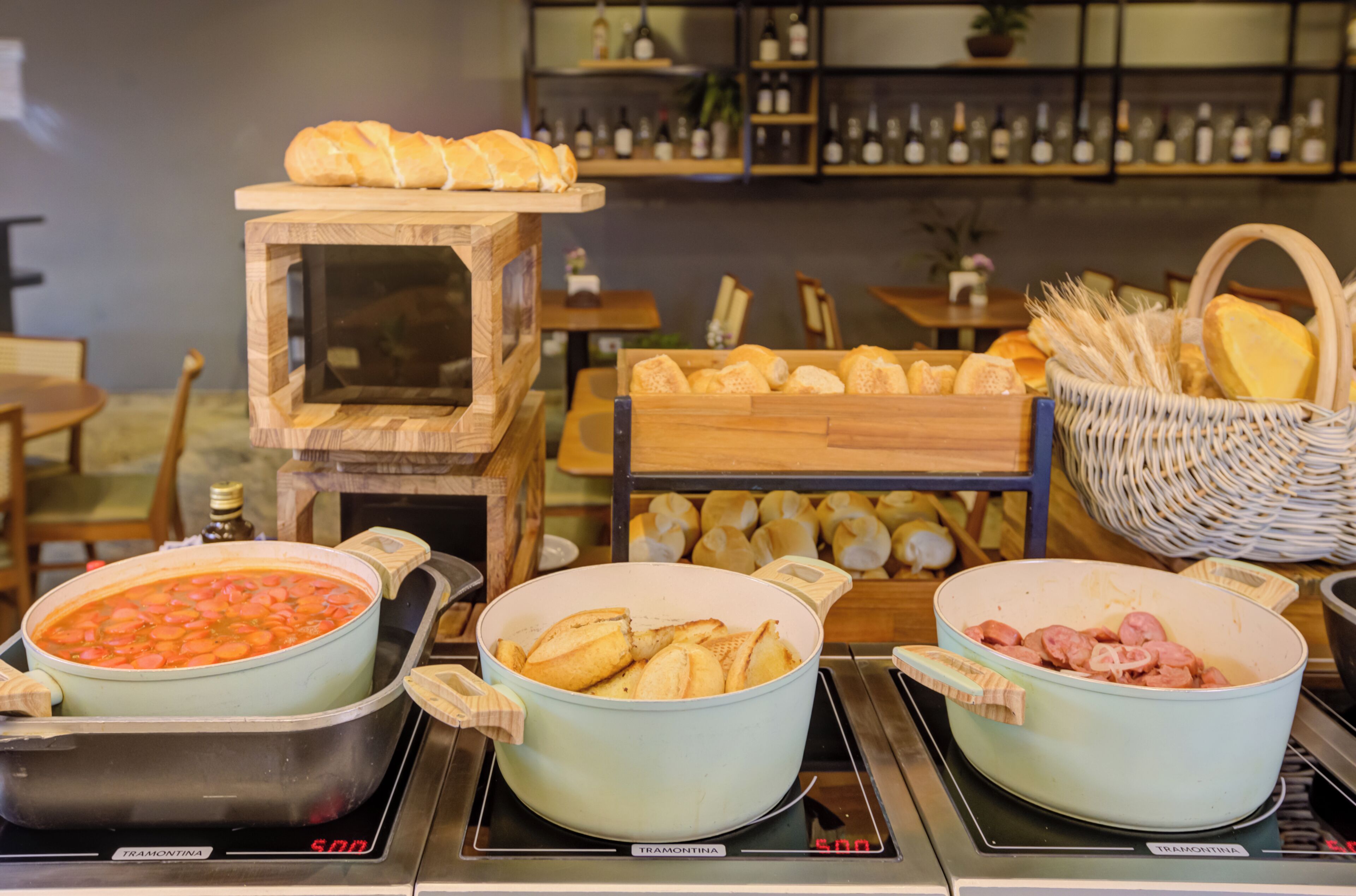 A buffet with various food items including a pot of soup, bread, and meat dishes.