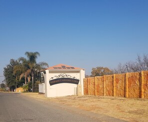 A sign for the Midrand Conference Centre with a white building and a wooden fence. - Midrand Conference Centre (Midrand)