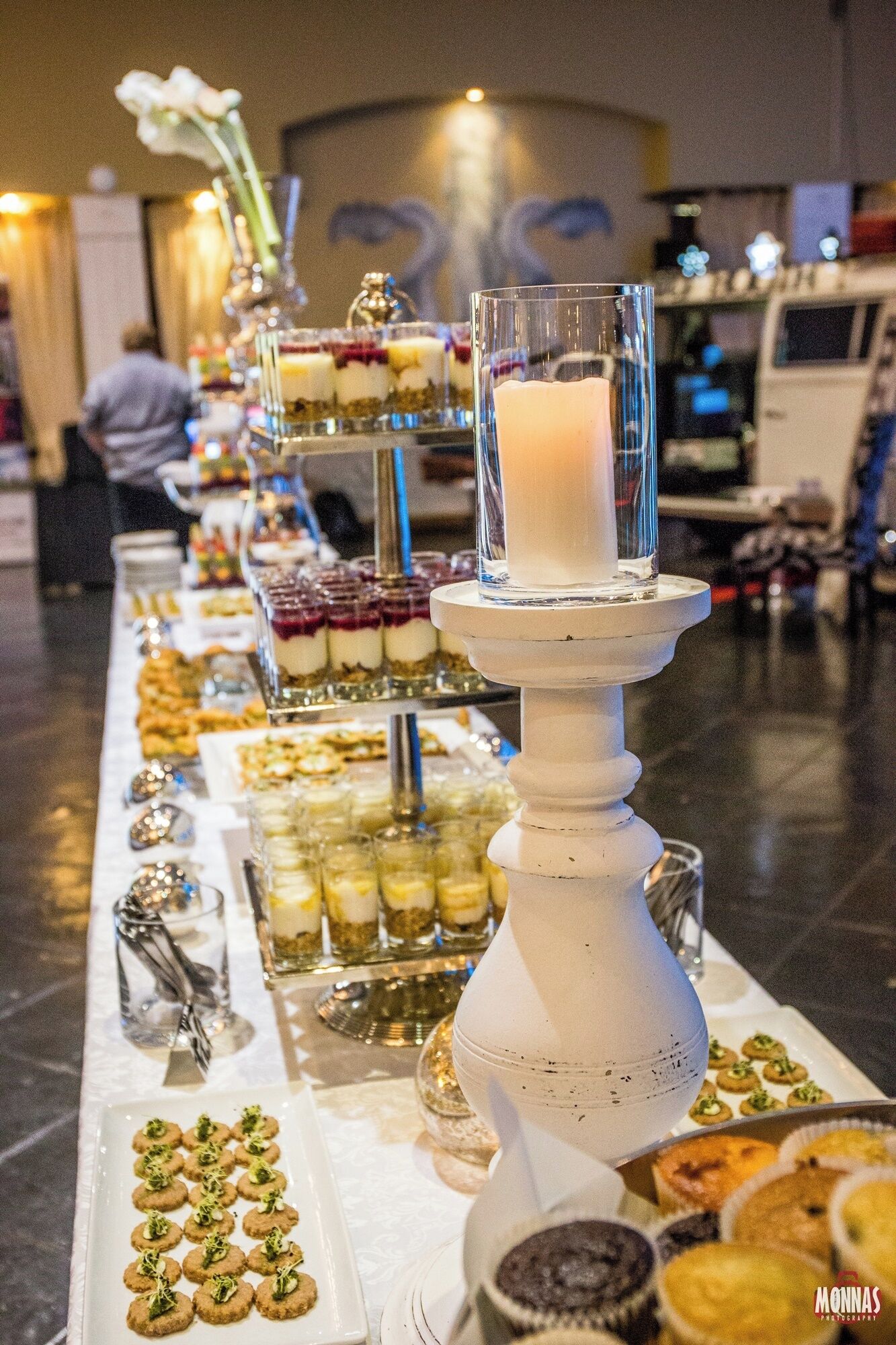 A buffet table with various food items and a candle centerpiece.