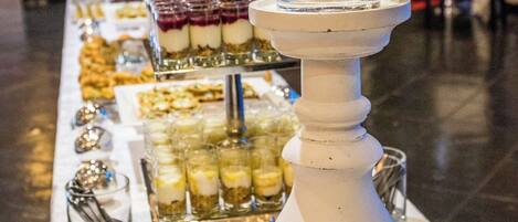 A buffet table with various food items and a candle centerpiece.