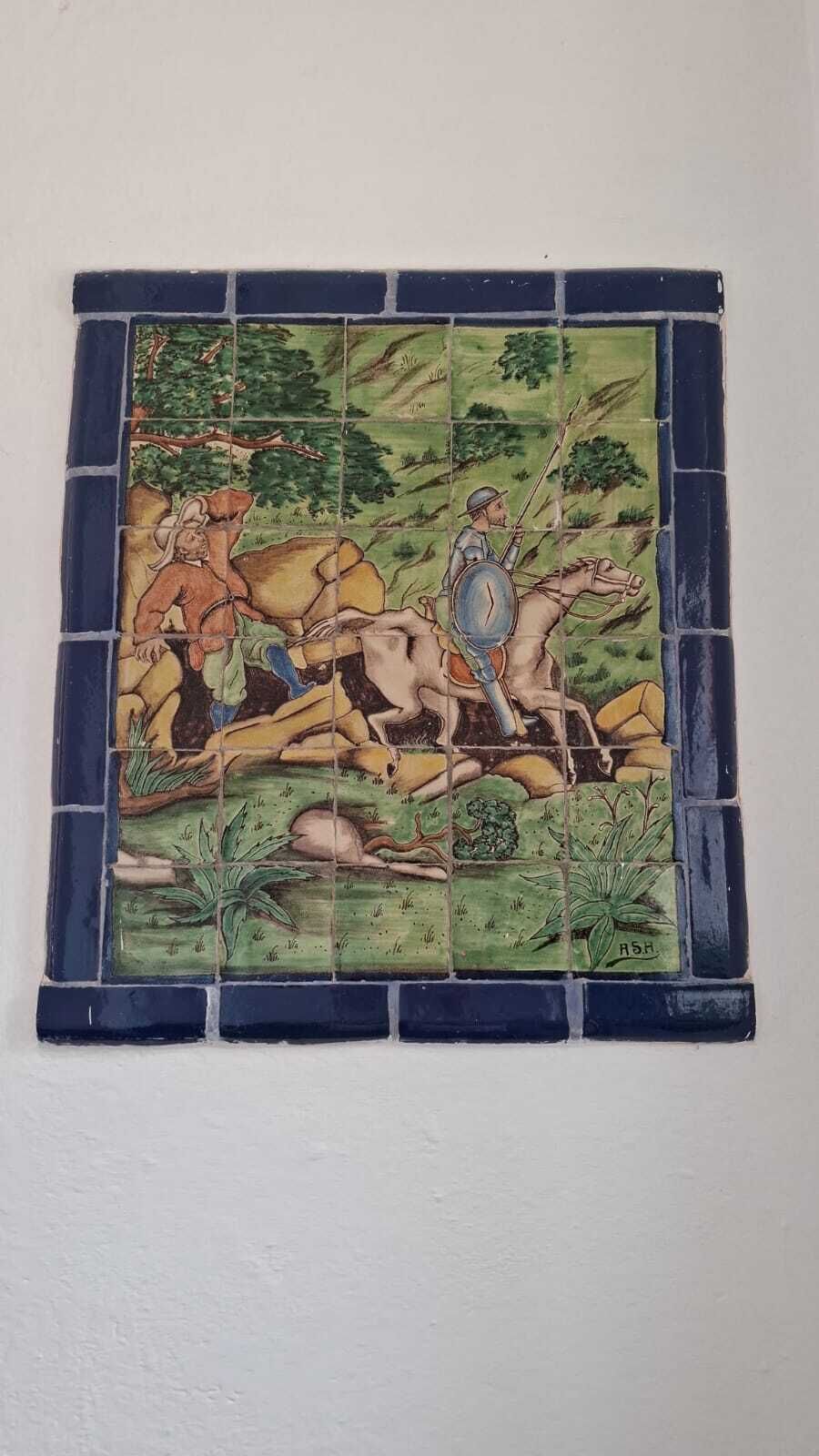 A mosaic tile wall with a historical scene.