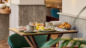A breakfast table with plates of food, cups, and a croissant. - Hotel Giacomo Morra Alba - Handwritten Collection (Alba)
