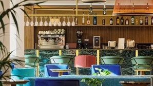 A bar area with seating, a coffee machine, and a wine display. - Hotel Giacomo Morra Alba - Handwritten Collection (Alba)