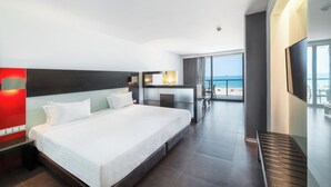 A modern hotel room with a large bed, a desk, and a balcony with a view. - RR Hotel da Rocha (Portimão)