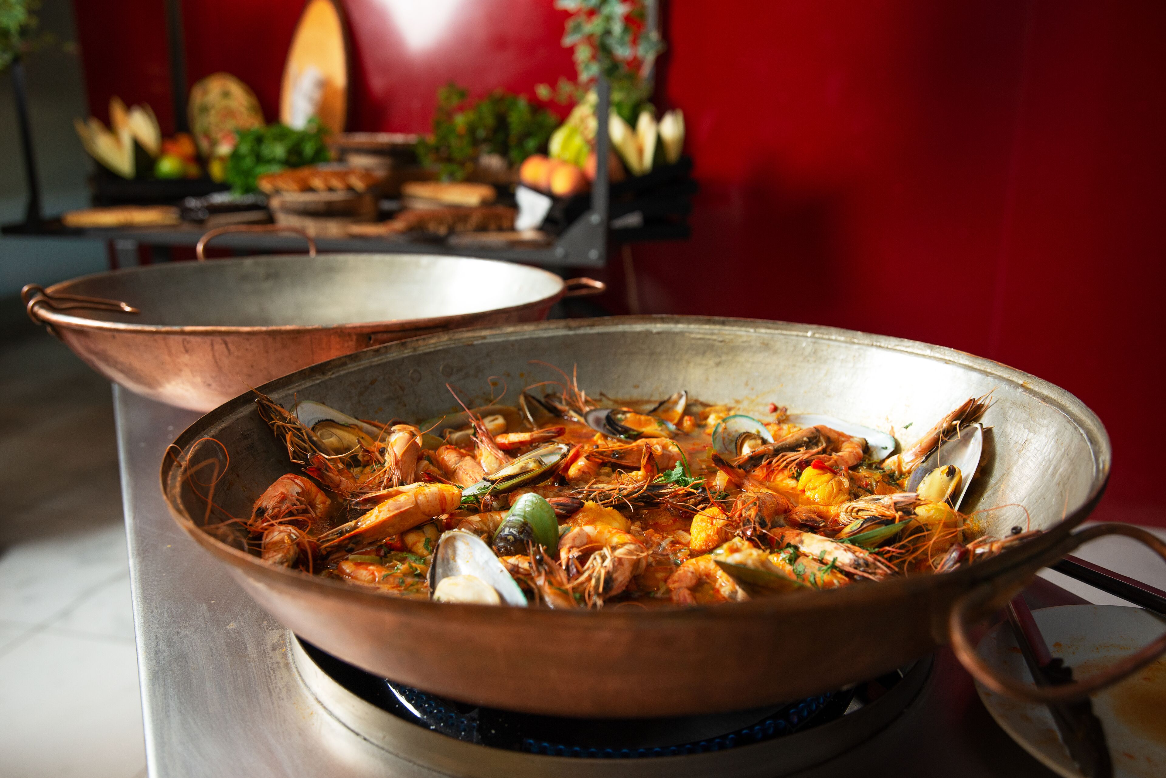 A large copper pan filled with seafood on a stove.