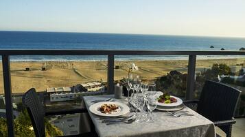 A table set for two with a view of the beach and ocean.