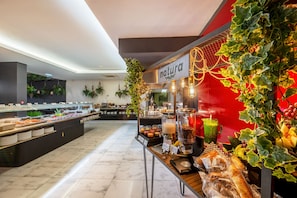 A buffet area with various food options, a juice bar, and a sign that reads "natura".
