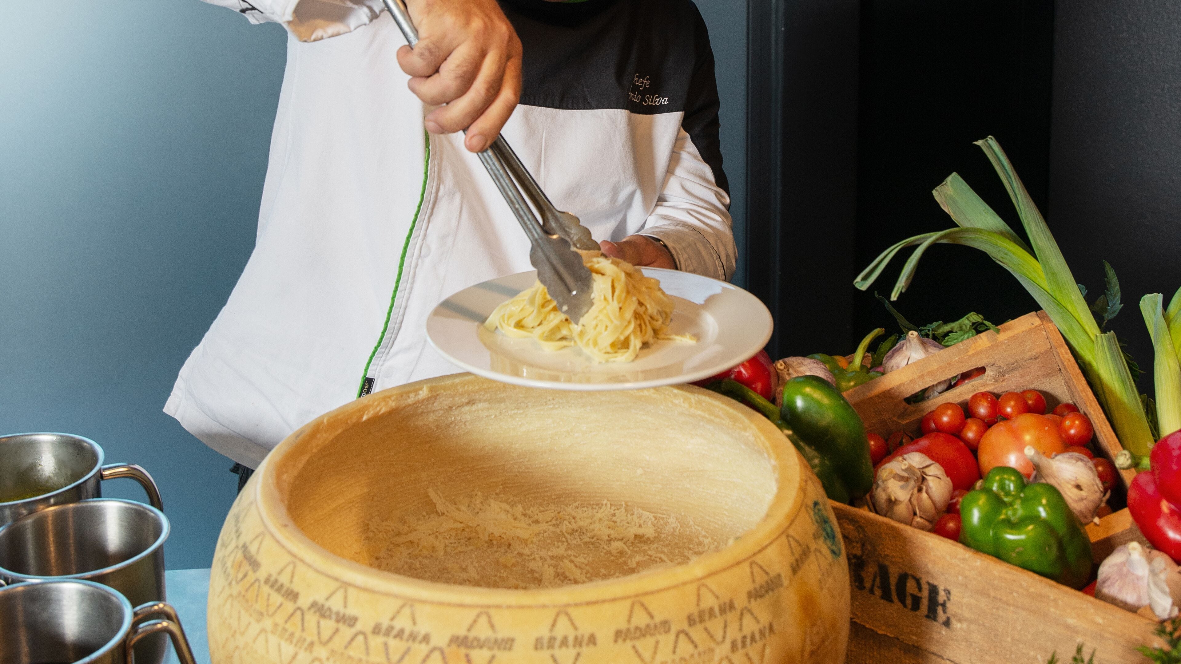 Una persona cocina pasta con pinzas sobre una olla grande.