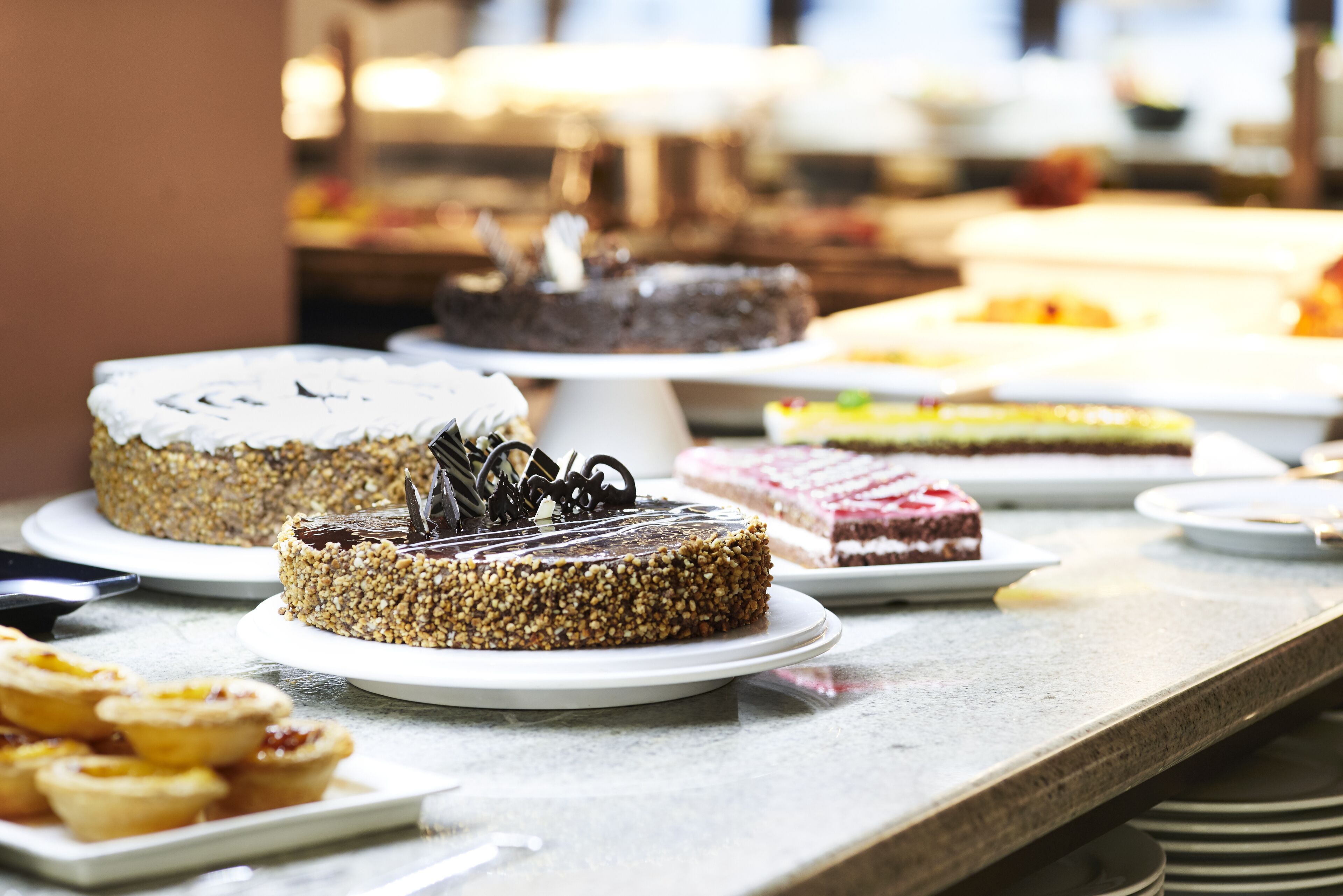 Uma mesa de buffet com diversos doces, incluindo bolos e tortas.