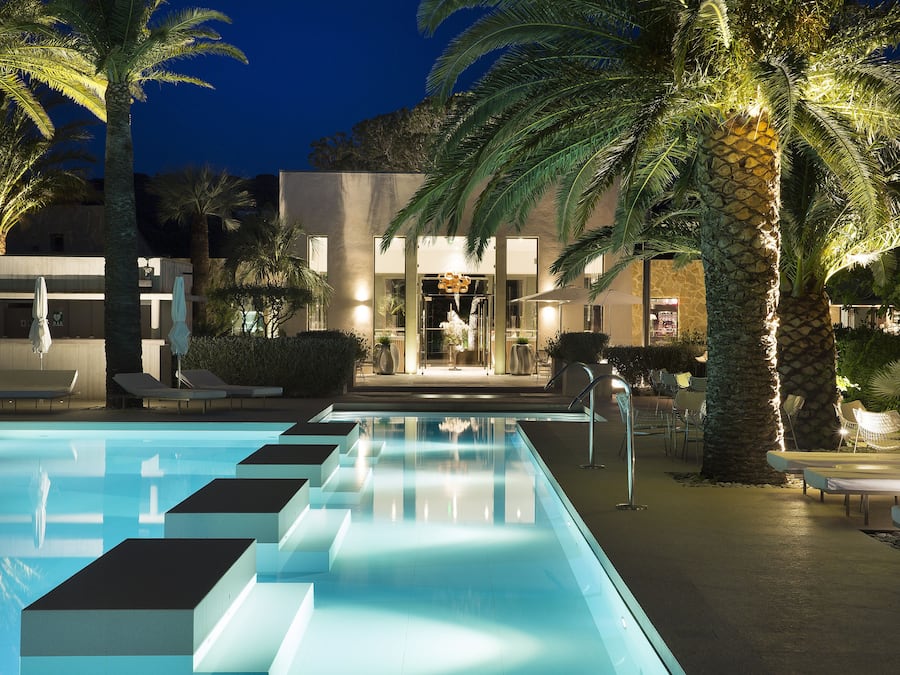 Una piscina al aire libre, sillones reclinables de piscina