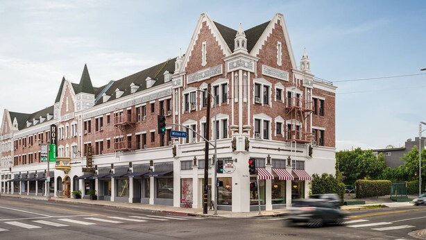 A historic building with a corner location, featuring a prominent entrance, multiple windows, and a fire escape.