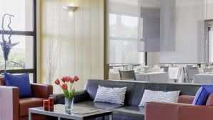 A modern hotel lobby with leather sofas, a coffee table, and a large window. - Best Western Park Hotel Geneve-Thoiry (Thoiry)