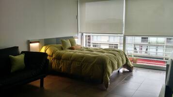 Relax in comfort with a large bed, sofa, and balcony view.
