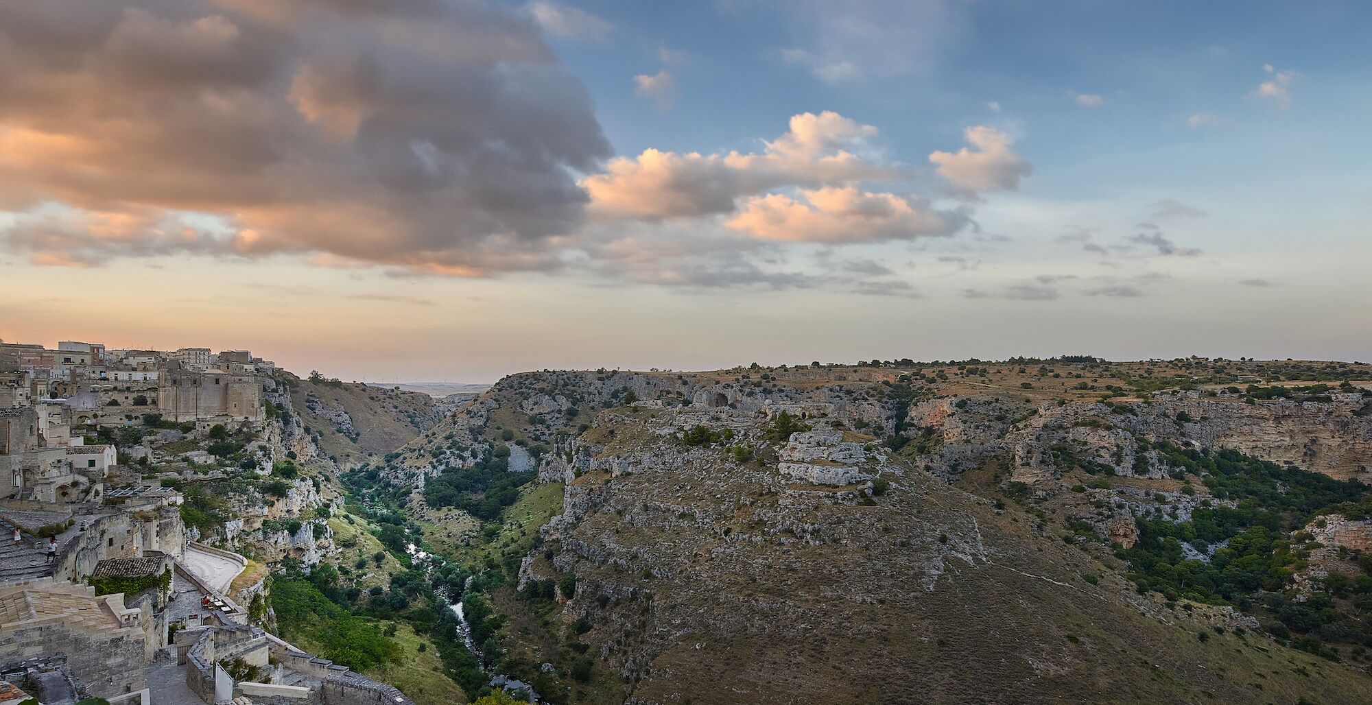 A panoramic view of a historic town with ancient ruins and a river valley.