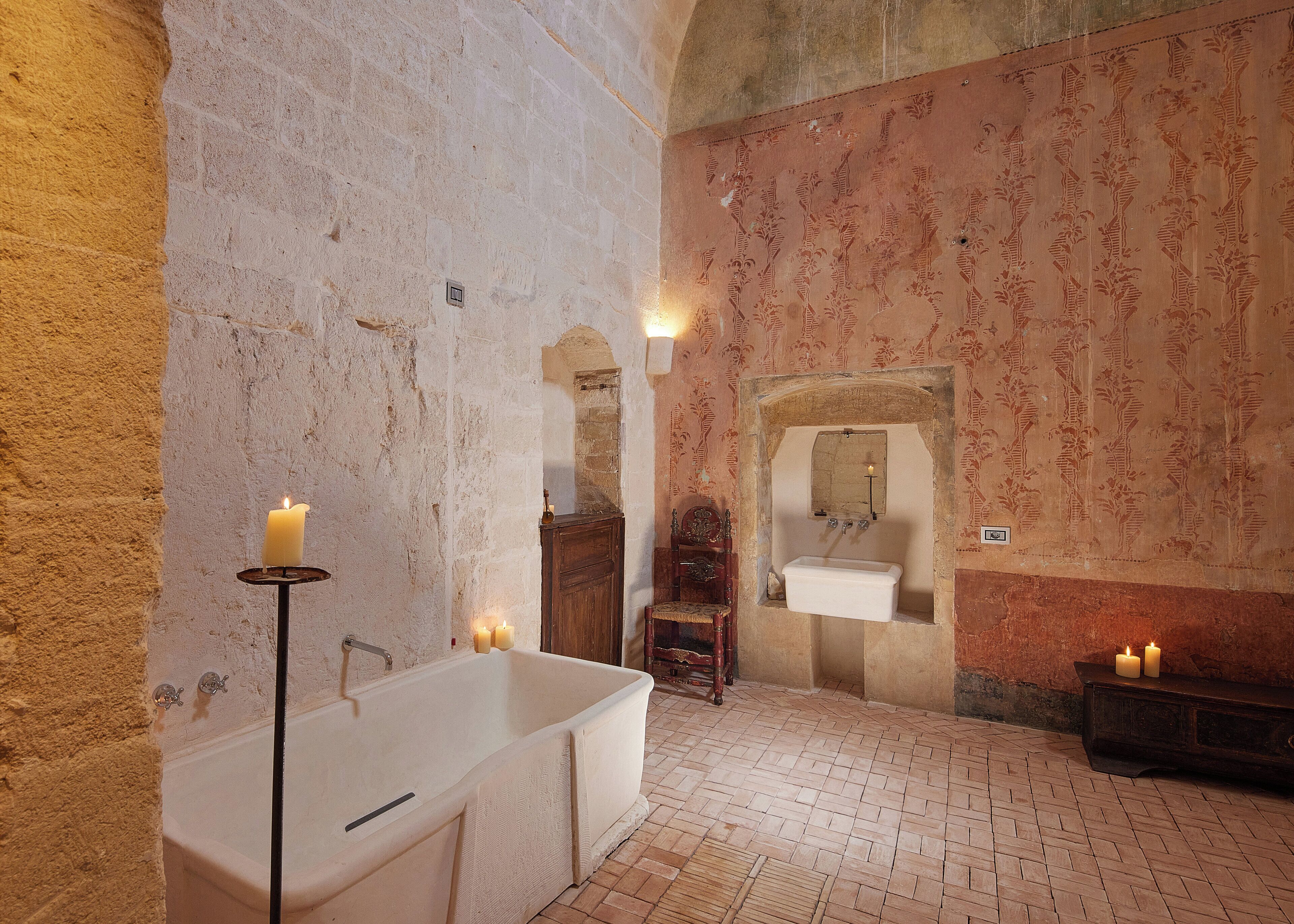 Un bagno con una vasca, un armadietto in legno, uno specchio e un lavandino.
