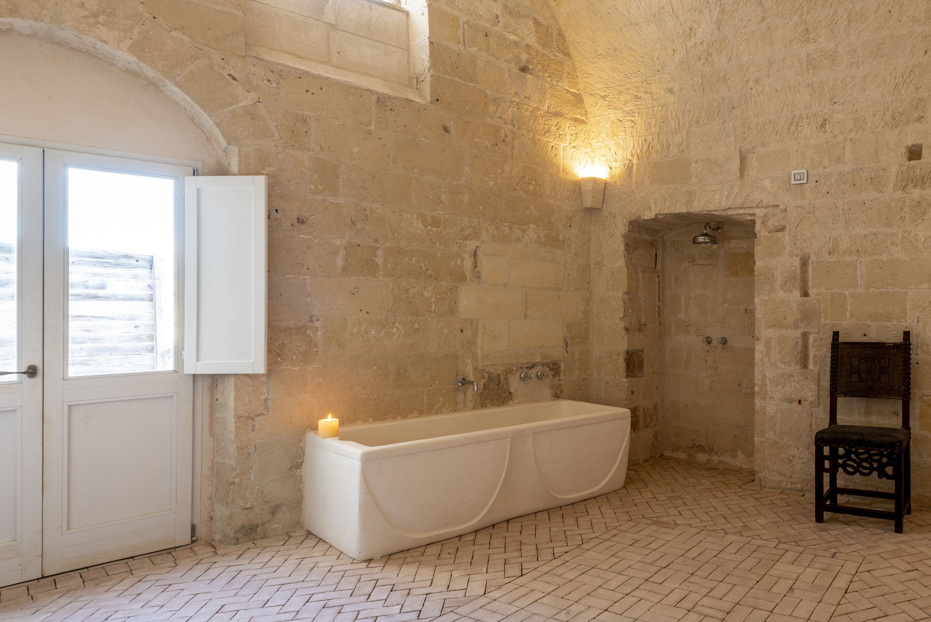 A bathroom with a bathtub, a shower, and a window.