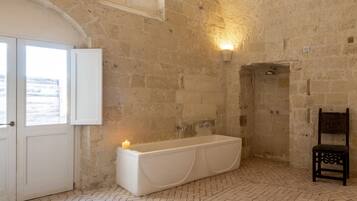 A bathroom with a bathtub, a shower, and a window.