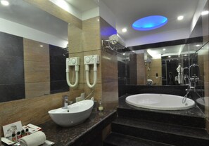 A modern bathroom with a large sink, a bathtub, and a shower area. - HK Clarks Inn, Amritsar (Amritsar)