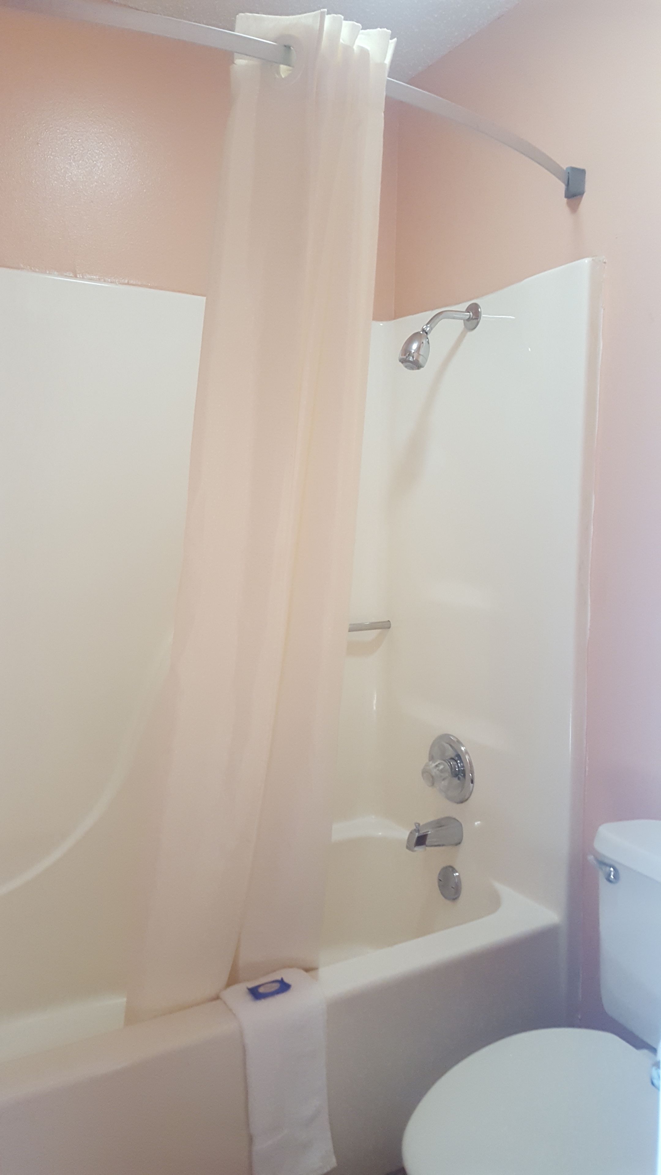 A bathroom with a bathtub, shower, and toilet.