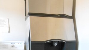 A compact kitchenette with a built-in refrigerator, a microwave, and a water dispenser. - Budget Inn Siloam Springs (Siloam Springs)