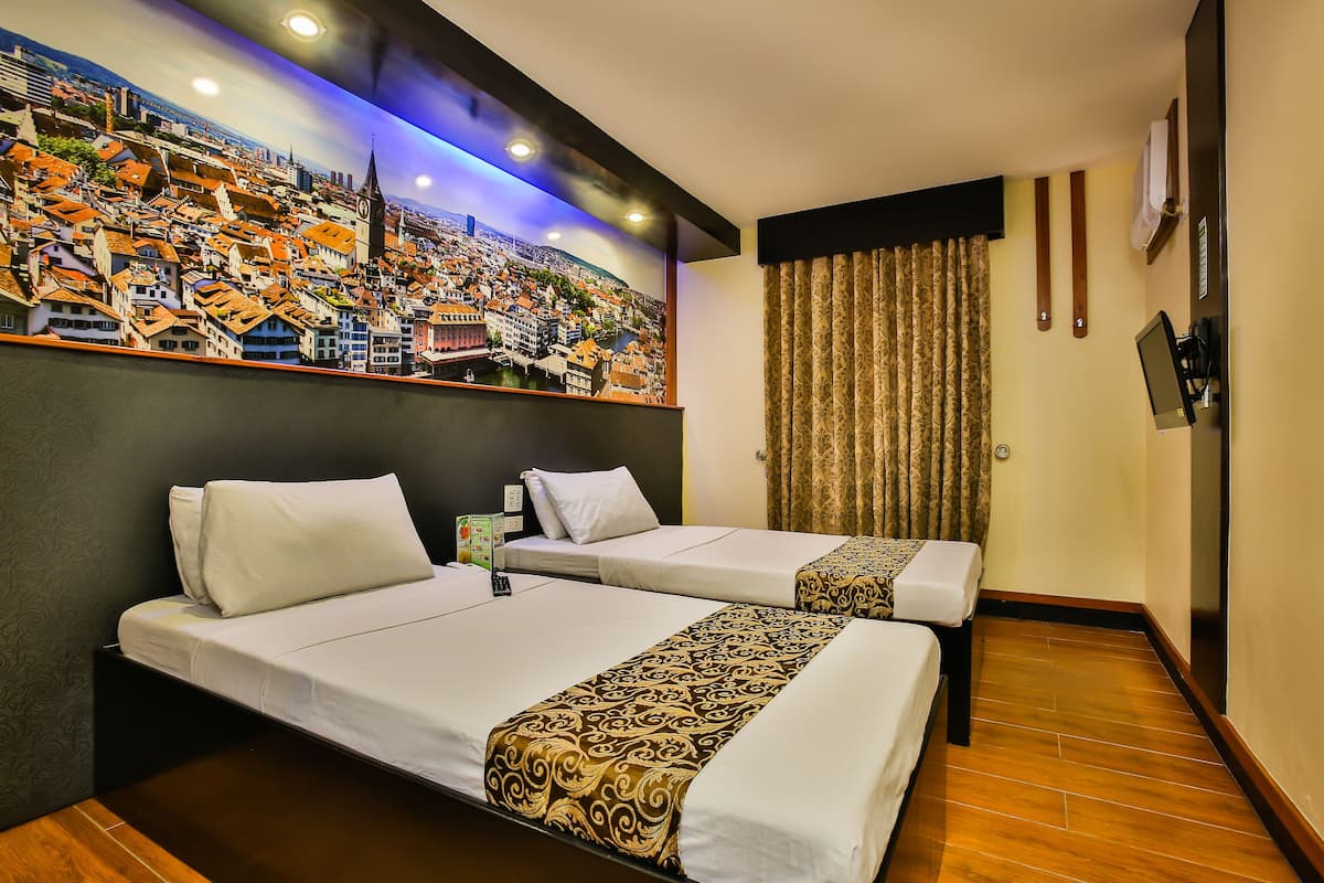A hotel room with two beds, a cityscape mural, a flat-screen TV, and a curtain.