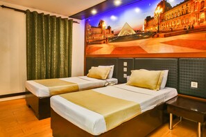 A hotel room with two beds, a large mural of a cityscape, and a wooden floor.
