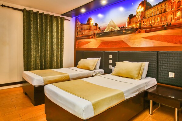Una habitación de hotel con dos camas, un mural grande de un paisaje urbano y suelo de madera.