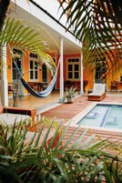 Un espacio exterior cubierto con piscina, asientos y plantas en macetas.