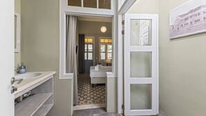 Ein Badezimmer mit einem weißen Waschbecken, einem Spiegel und einem gemusterten Boden.