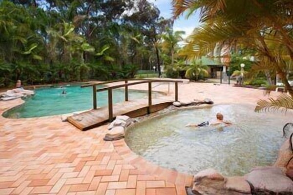 Una piscina al aire libre, sillones reclinables de piscina