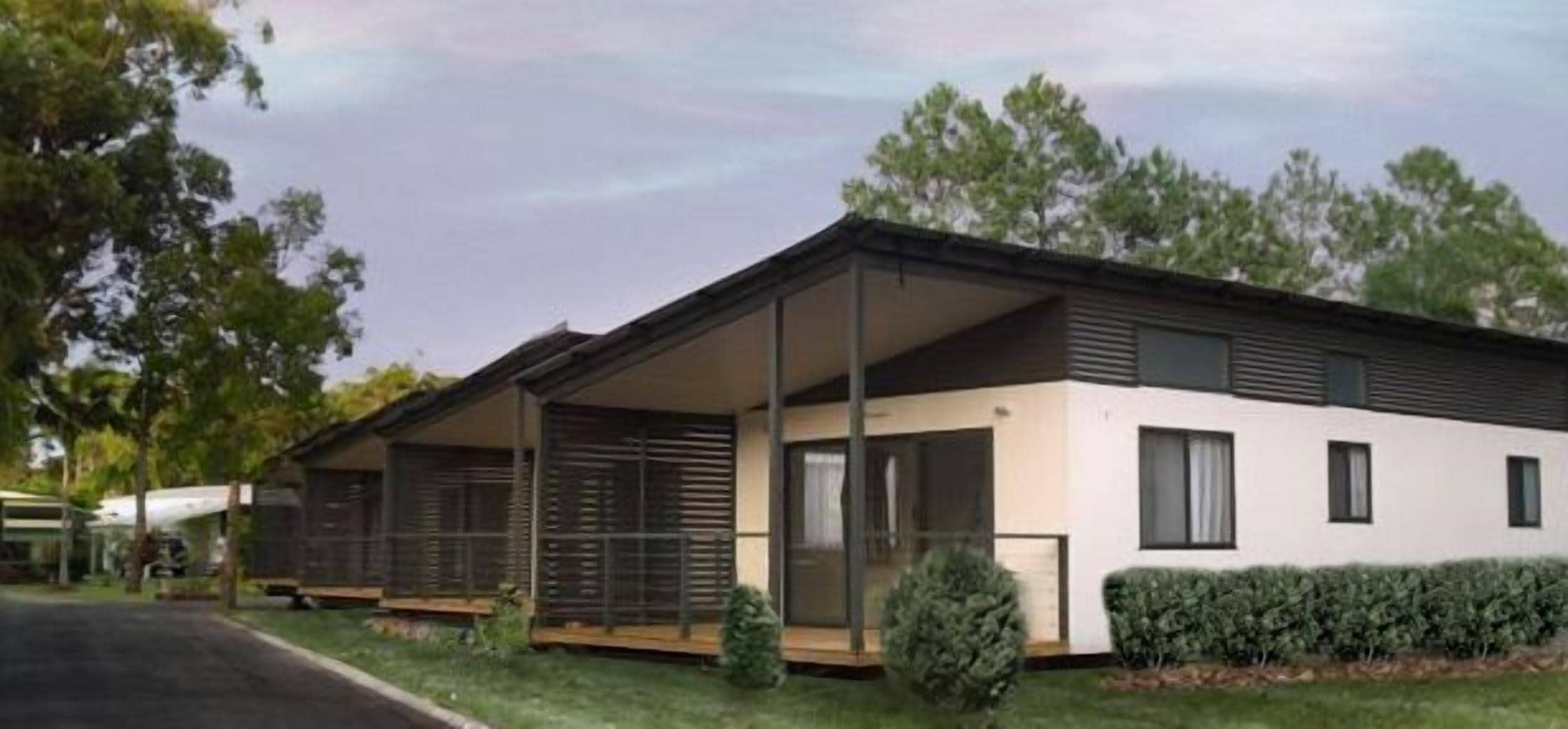 A modern two-story house with a covered porch, large windows, and a well-maintained lawn.