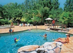 Una piscina al aire libre, sillones reclinables de piscina