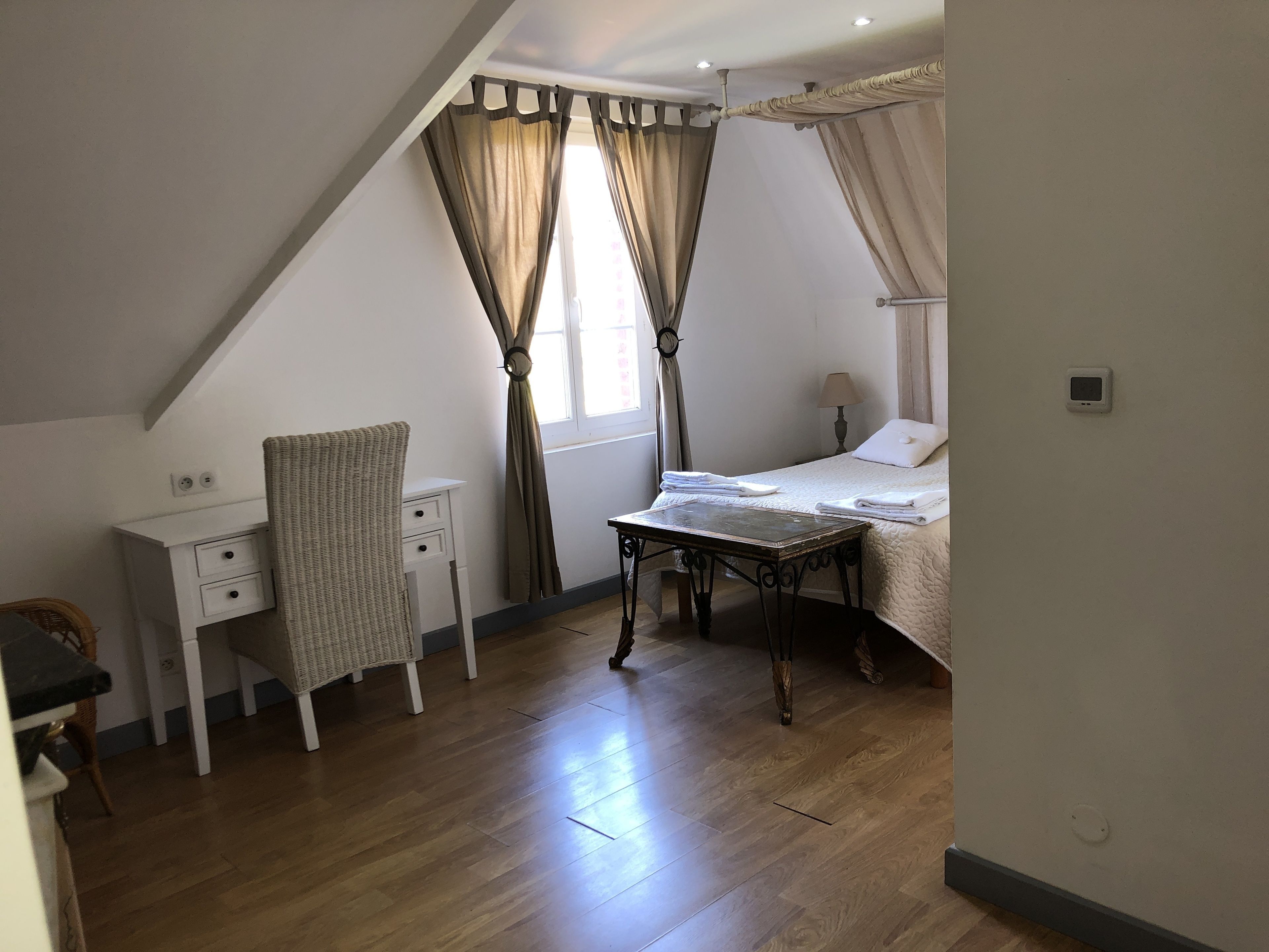 A bedroom with a bed, a desk, and a chair.