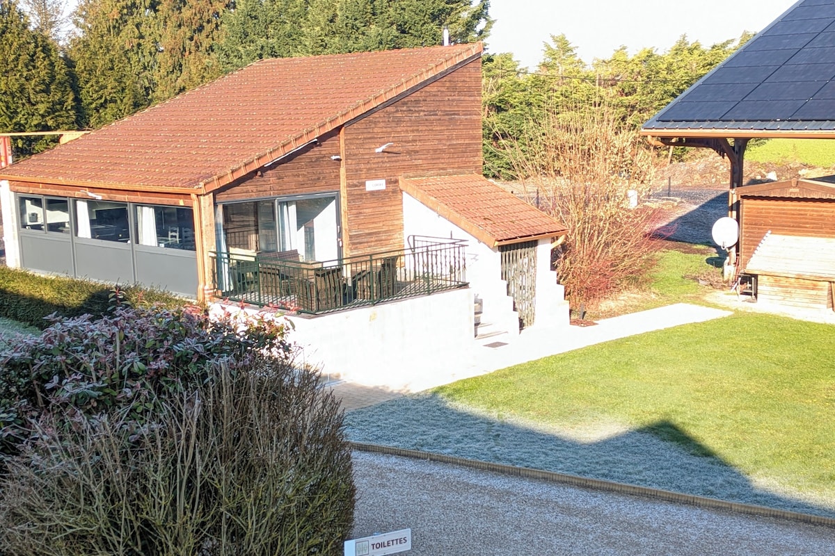 Un bâtiment avec un toit recouvert de tuiles rouges, un balcon et un panneau indiquant l’emplacement des toilettes.