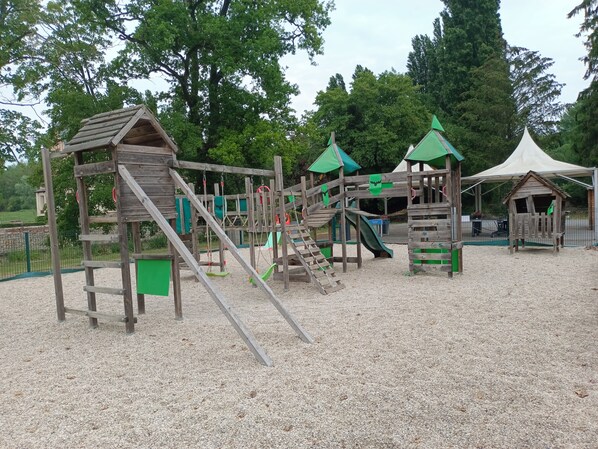 Ein Spielplatz mit Holzkonstruktionen, Rutschen und Kletterbereichen.