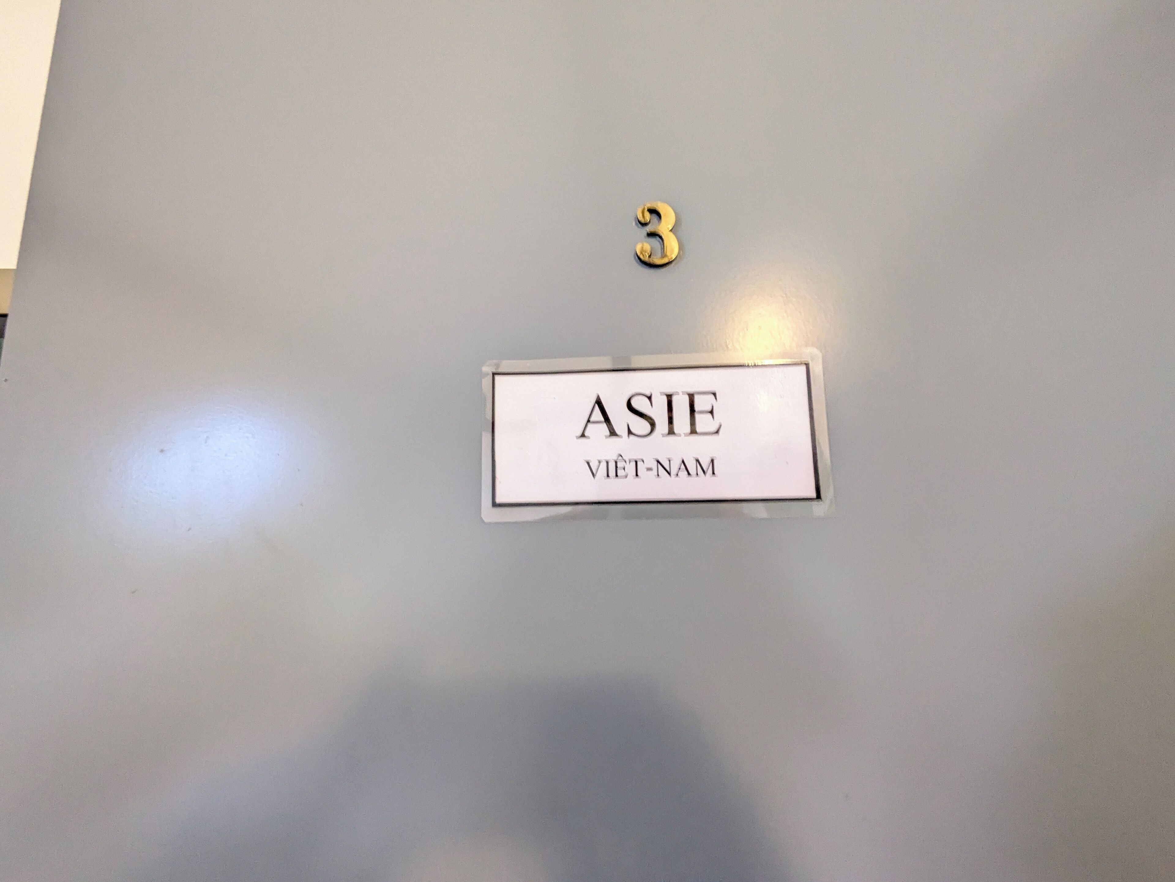 A room number sign with the number 3 and a nameplate that reads "ASIE VIET-NAM".