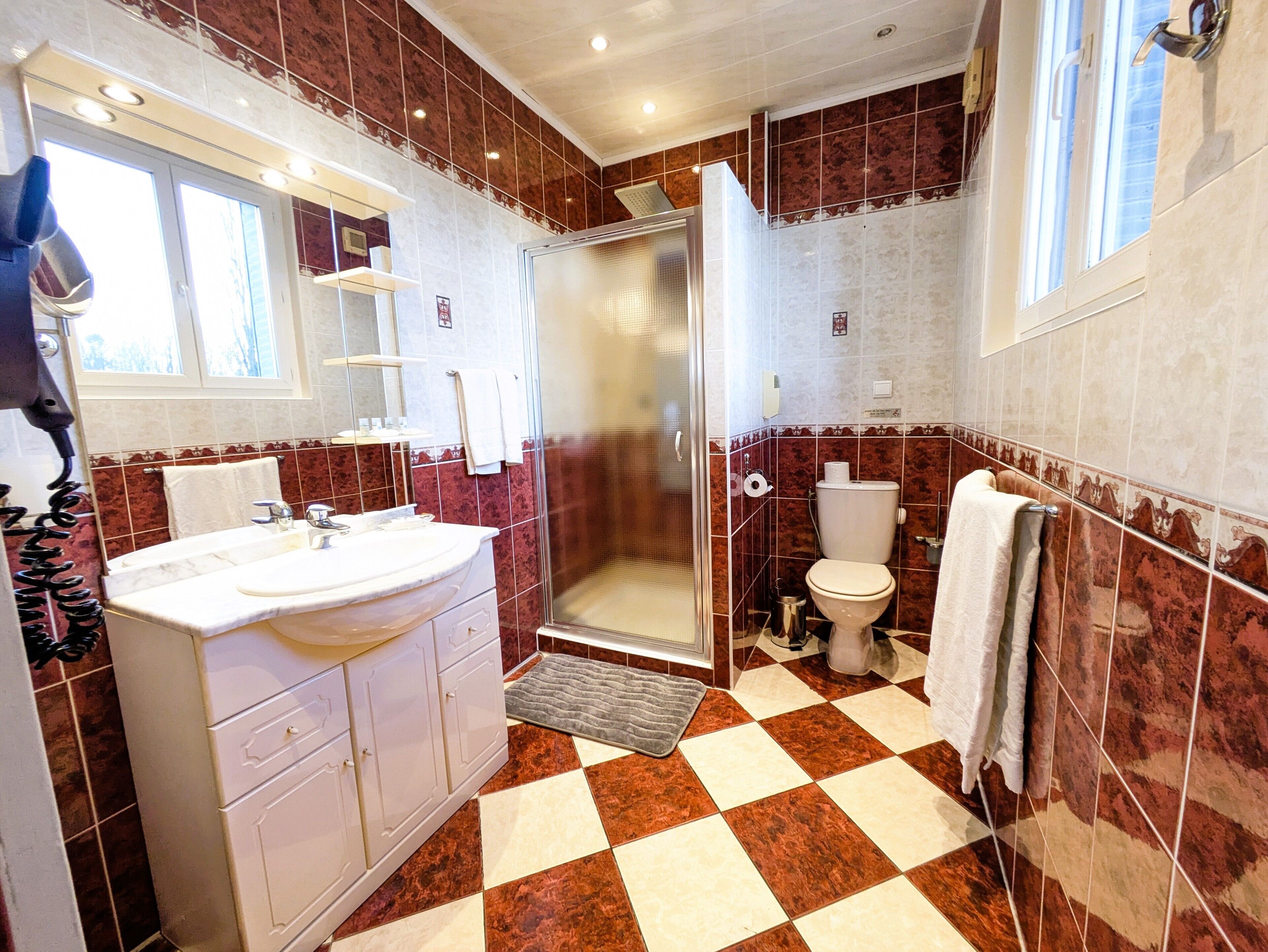 A bathroom with a shower, toilet, and sink.
