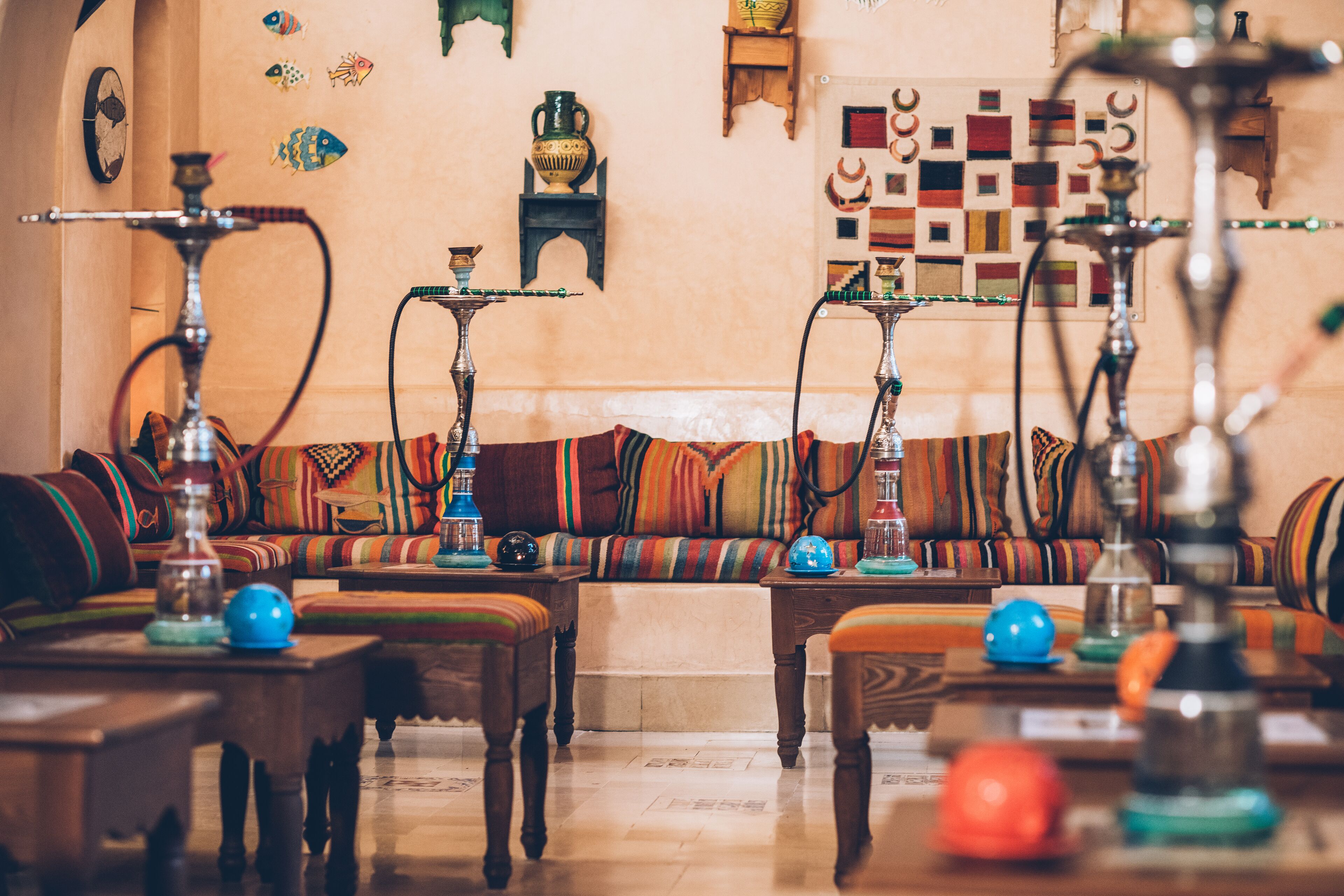 Un salón tradicional con sofá, mesas de madera y varios cachimbos.