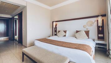 A hotel room with a large bed, a bench, a wooden headboard, and a ceiling light fixture.