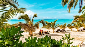 On the beach, white sand, sun-loungers, beach towels