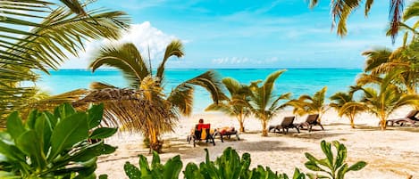 On the beach, white sand, sun-loungers, beach towels